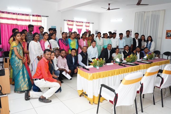 Group of people posing for photo inside community center