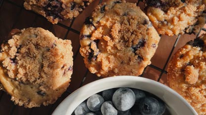 Des muffins aux myrtilles avec un bol de myrtilles.