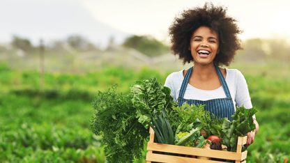 Une femme debout dans un jardin avec une boîte de produits