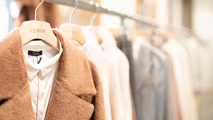 Manteau marron et vêtements sur des cintres