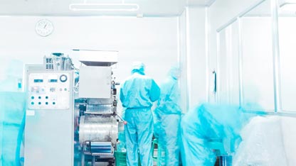 Équipement de l'industrie pharmaceutique et technicien dans une salle blanche