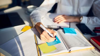 Une femme prends des notes sur son cahier au travail